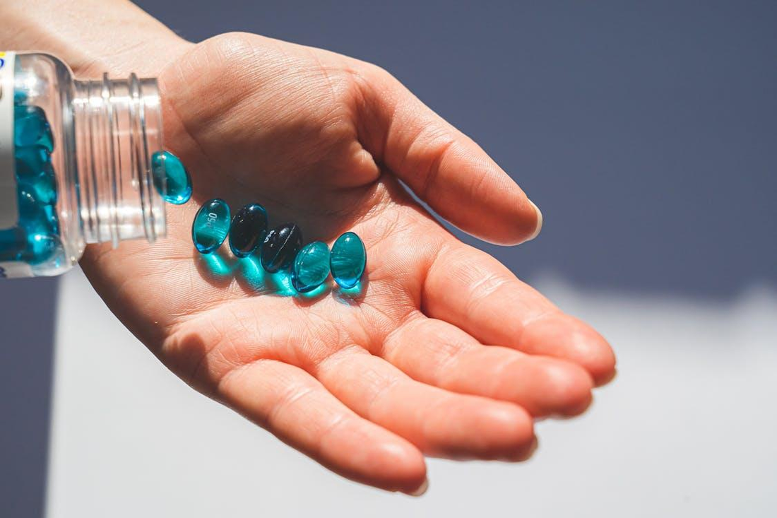 Hand holding blue pills 